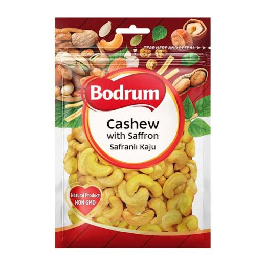 A package of Bodrum Cashew with Saffron (Safrali Kaju) nuts. The packaging is a clear plastic bag showing the golden-yellow cashews inside, with a red and white central logo and a red header decorated with illustrations of various nuts and green leaves.