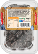 Packaged prunes with a label on a wooden surface
