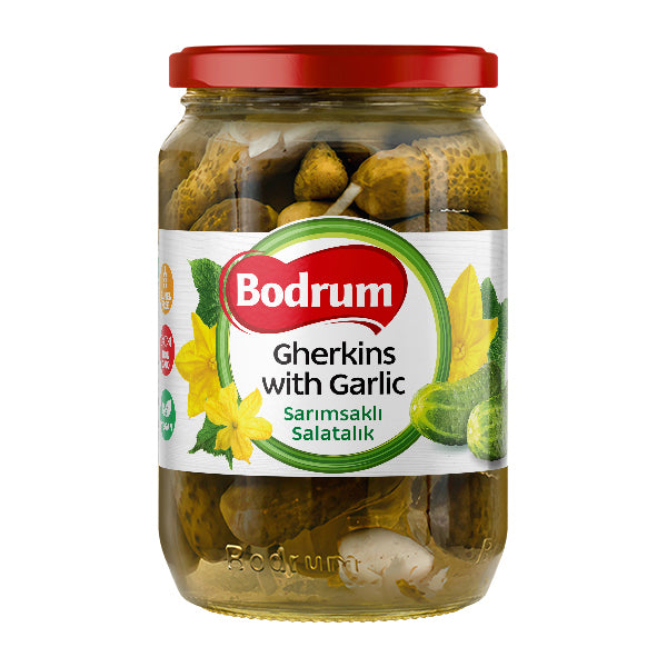 Jar of Bodrum gherkins with garlic on a white background