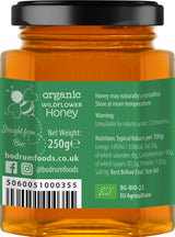 Jar of organic wildflower honey with label showing brand information and nutritional details.